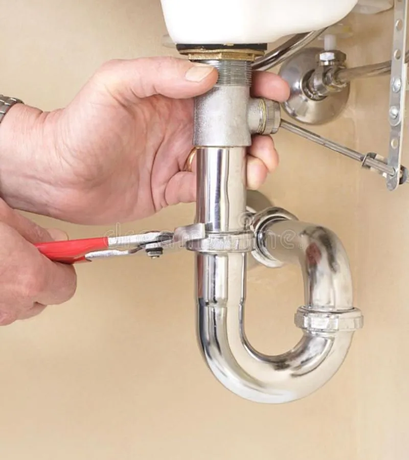 Professional plumber performing a bathroom sink fixture installation and P-trap assembly in a Dallas residence.