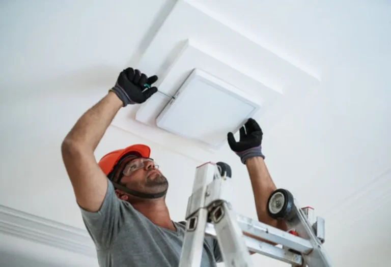 Professional electrician installing a modern square LED ceiling light fixture in a Dallas home.